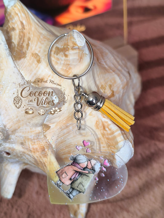 Porte-clé cœur transparent “Amour Éternel – Douce Étreinte” – Couple âgé enlacé – Franges suédine jaune – Modèle unique