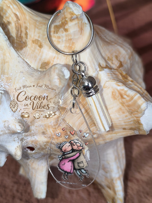 Porte-clé goutte d’eau transparent “Amour Éternel – Tendresse Partagée” – Couple âgé enlacé – Franges suédine beige – Modèle unique