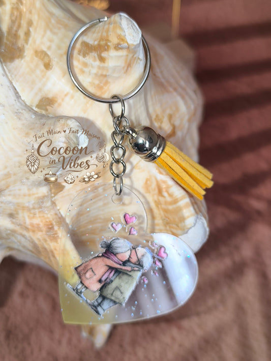Porte-clé cœur transparent “Amour Éternel – Douce Étreinte” – Couple âgé enlacé – Franges suédine jaune – Modèle unique