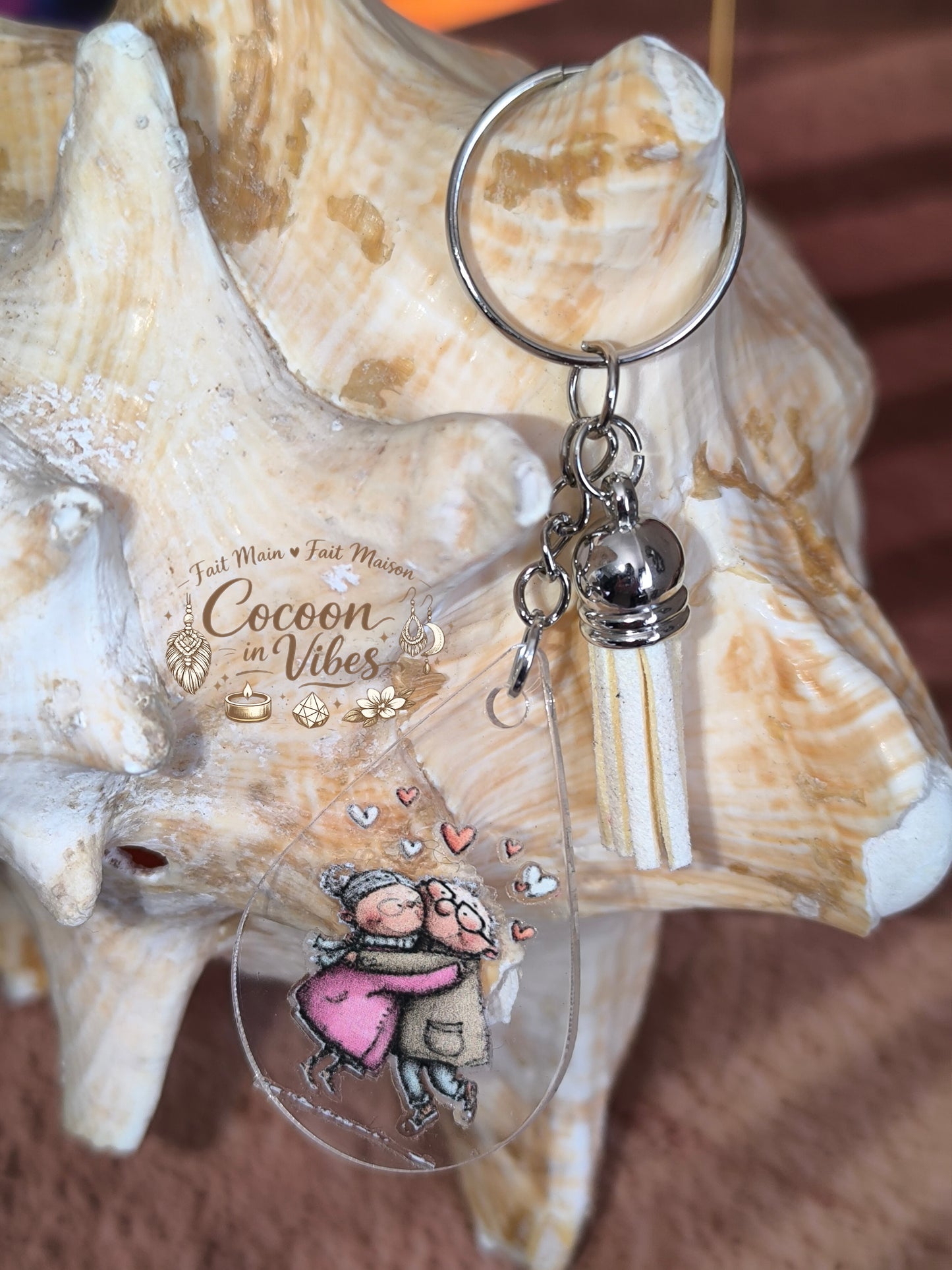 Porte-clé goutte d’eau transparent “Amour Éternel – Tendresse Partagée” – Couple âgé enlacé – Franges suédine beige – Modèle unique