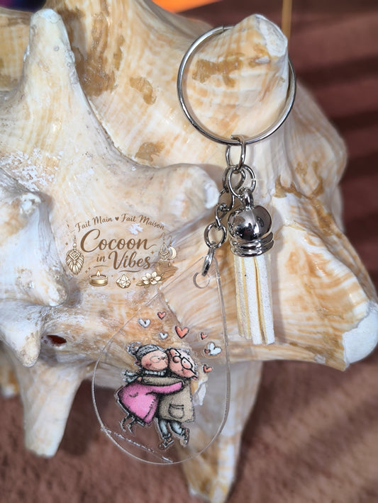 Porte-clé goutte d’eau transparent “Amour Éternel – Tendresse Partagée” – Couple âgé enlacé – Franges suédine beige – Modèle unique